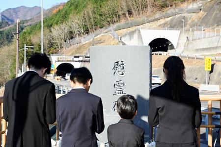 　中央自動車道笹子トンネル出口付近の慰霊碑に黙とう、献花する遺族ら＝２日午前、山梨県大月市（代表撮影）